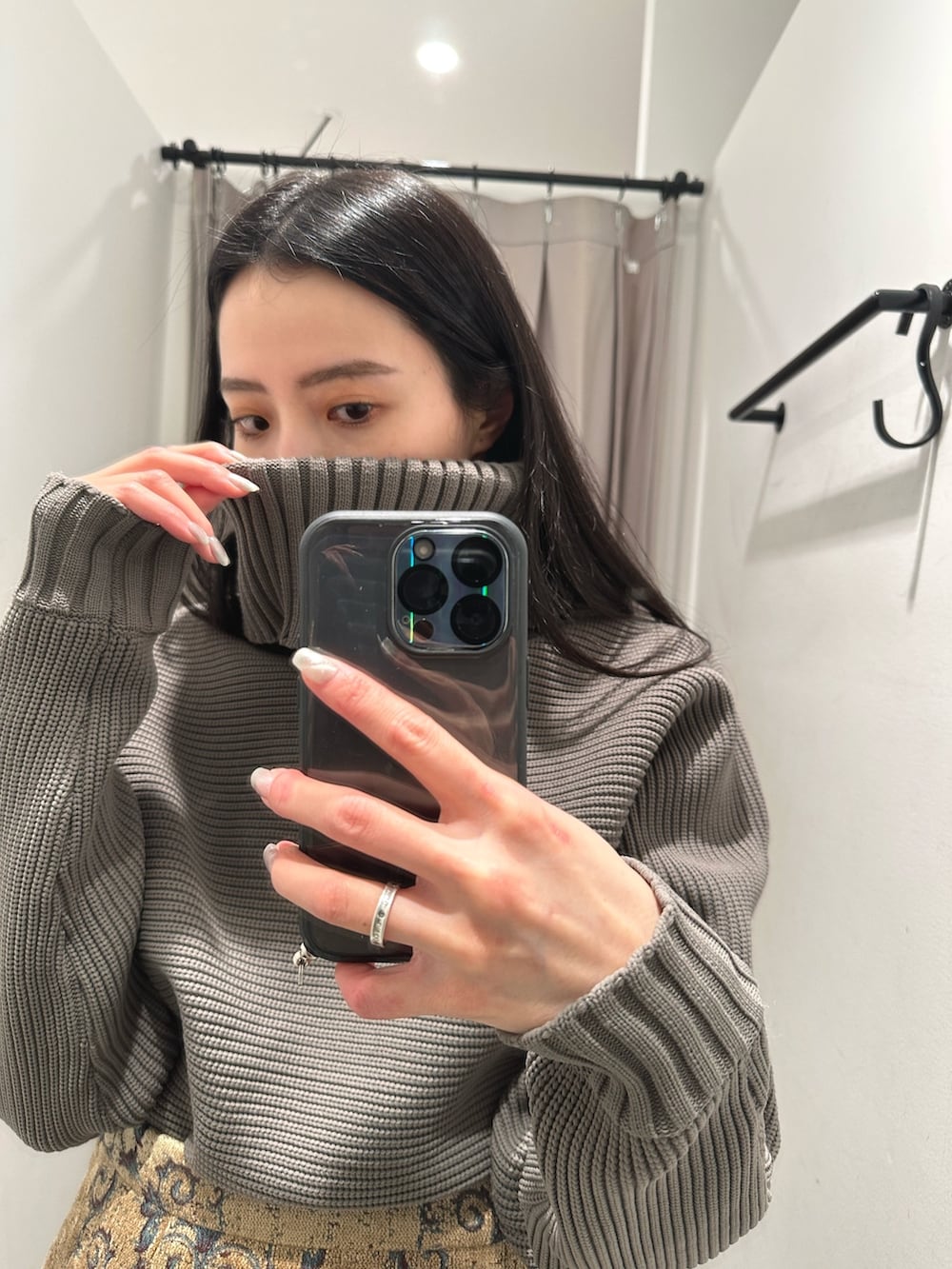 ベージュ系のニット/セーター、ブラウン系のスカートを着用したレディースの冬コーディネートの3枚目の写真