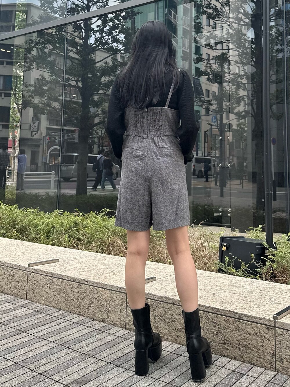 グレー系のワンピース、ブラック系のニット/セーター、ブラック系のブーツを着用したレディースの秋コーディネートの2枚目の写真