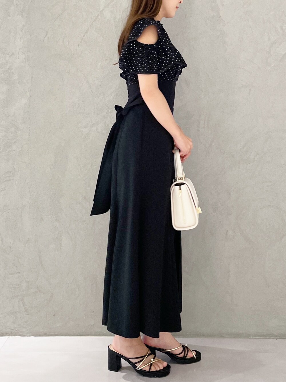 ホワイト系のショルダーバッグ、ブラック系のサンダル、その他のワンピースを着用したレディースの春コーディネートの2枚目の写真