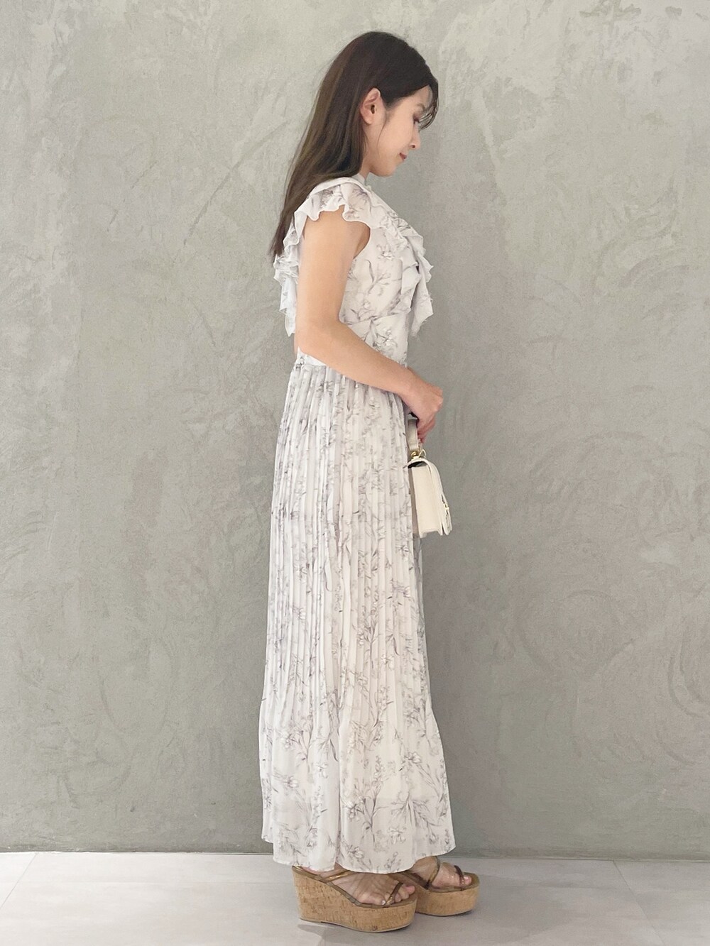 ホワイト系のハンドバッグ、ブラウン系のサンダル、ピンク系のワンピースを着用したレディースの春コーディネートの2枚目の写真