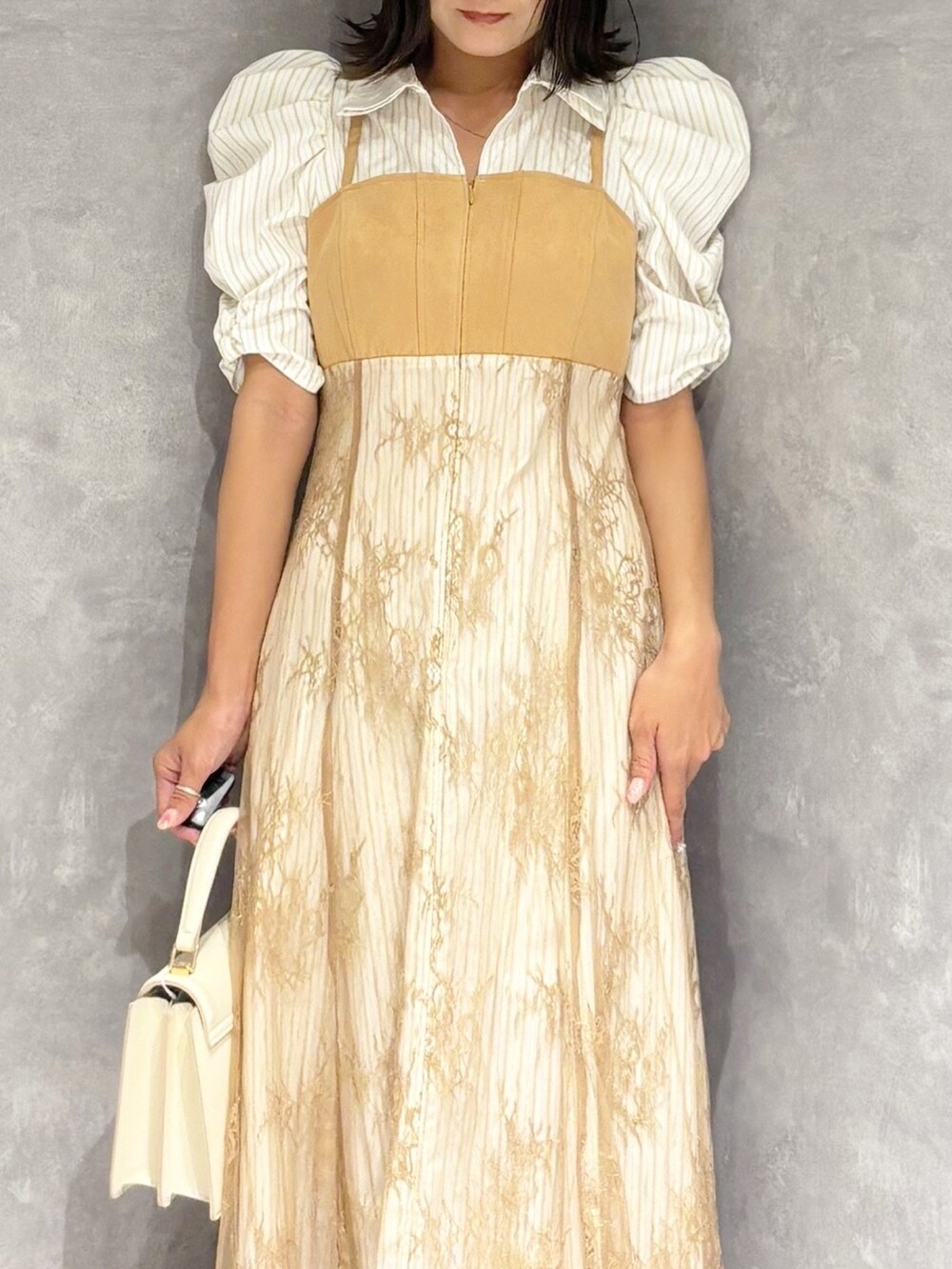 ベージュ系のワンピース、シルバー系のパンプス、ホワイト系のハンドバッグを着用したレディースの夏コーディネートの5枚目の写真