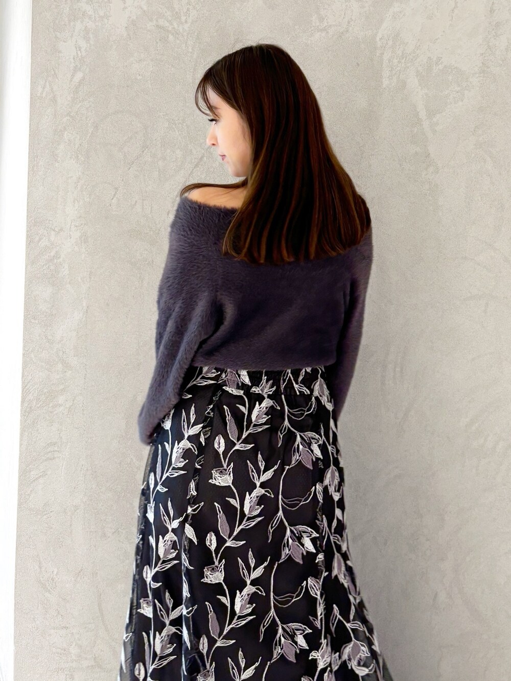 グレー系のスカート、ブラック系のブーツ、ブラック系のショルダーバッグを着用したレディースの秋コーディネートの7枚目の写真