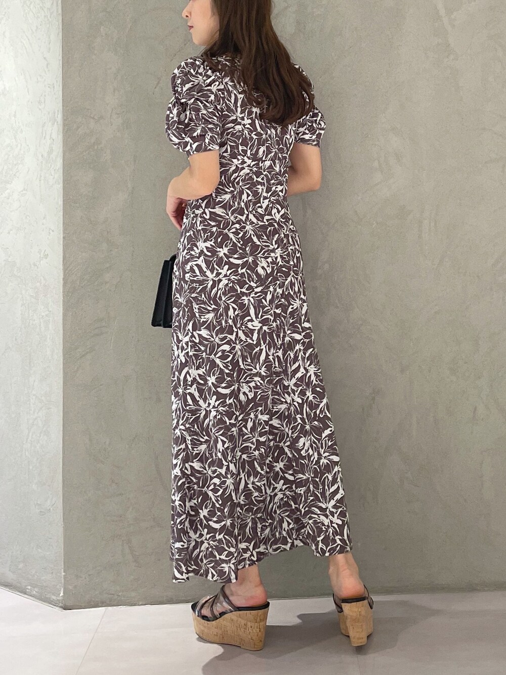 ブラック系のサンダル、ブラック系のハンドバッグ、グレー系のワンピースを着用したレディースの春コーディネートの6枚目の写真