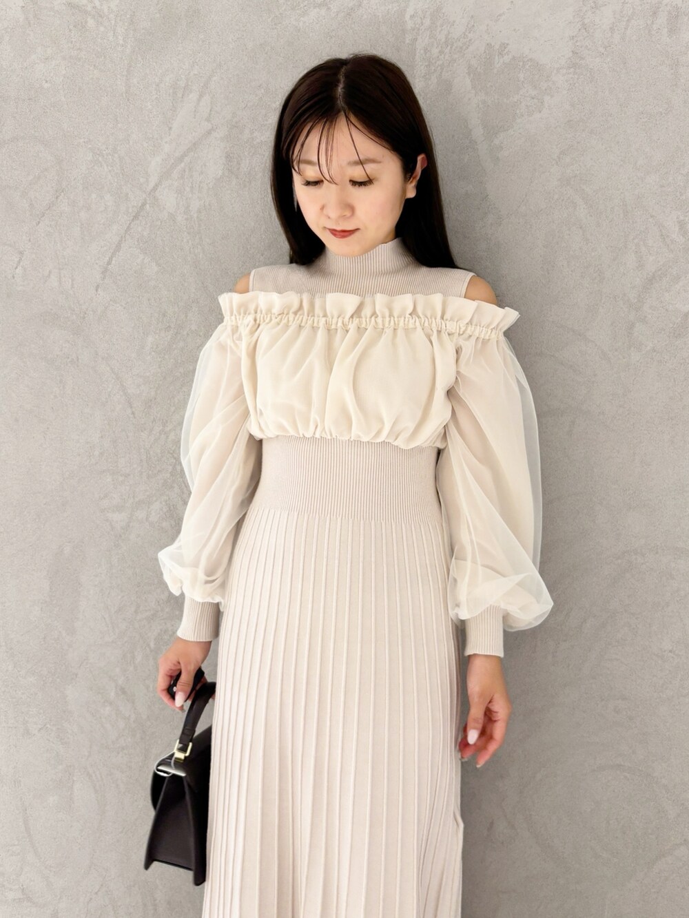 ホワイト系のワンピース、ブラウン系のブーツ、ブラウン系のハンドバッグを着用したレディースの冬コーディネートの6枚目の写真