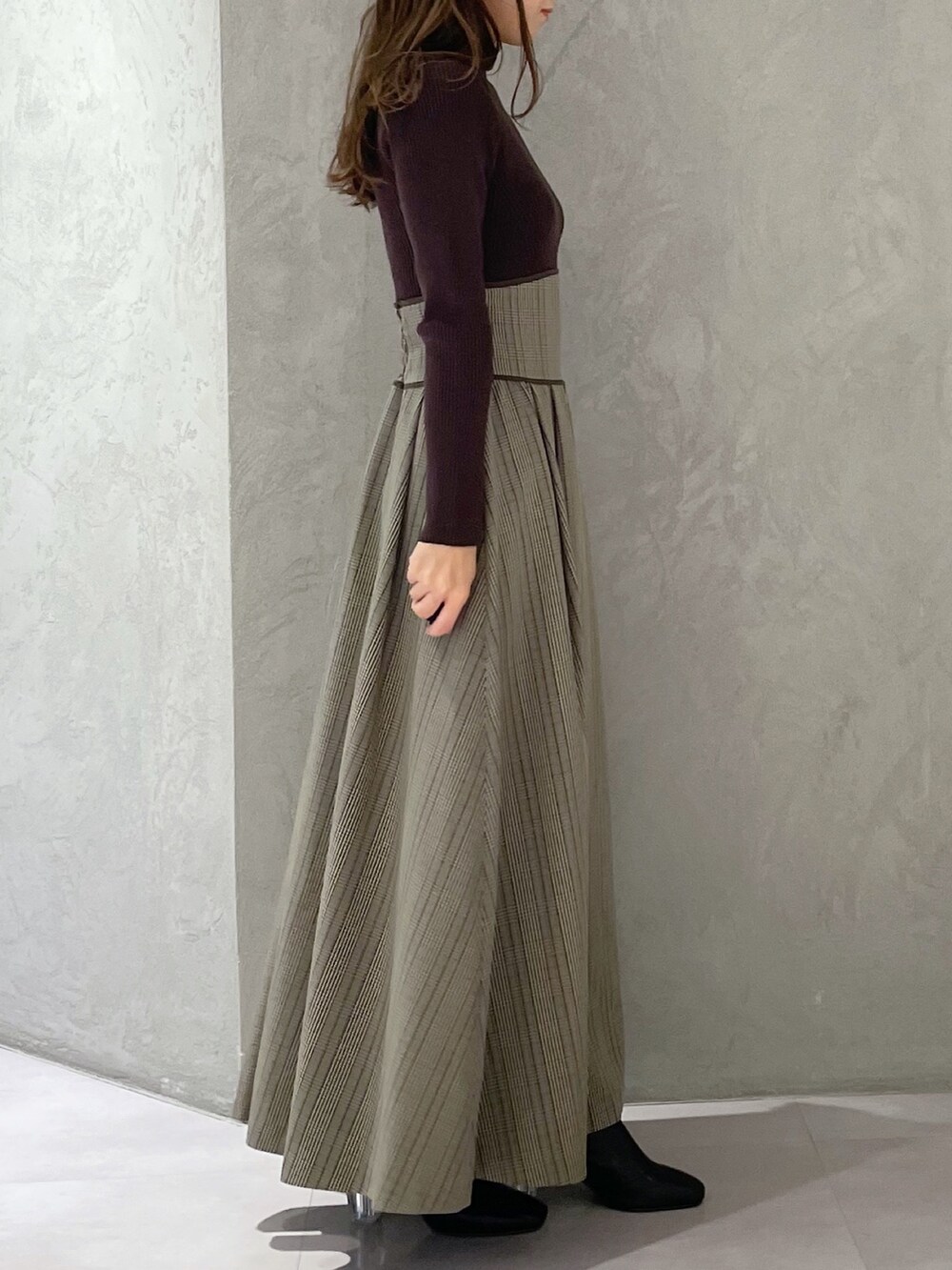 ブラウン系のワンピース、ブラック系のブーツを着用したレディースの冬コーディネートの4枚目の写真