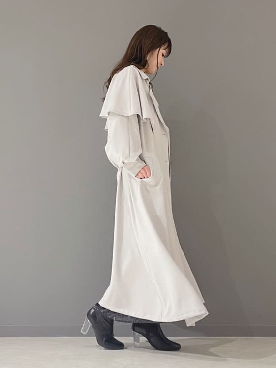 ブラック系のワンピース、ブラック系のその他シューズ、グレー系のトレンチコートを着用したレディースの冬コーディネートの5枚目の写真