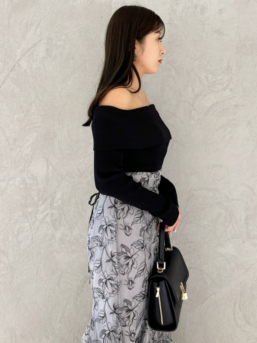 グレー系のスカート、ブラック系のブーツ、ブラック系のショルダーバッグを着用したレディースの秋コーディネートの4枚目の写真