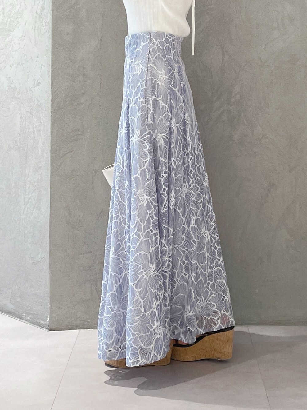 ブルー系のスカート、ブラック系のサンダル、ホワイト系のトートバッグを着用したレディースの夏コーディネートの5枚目の写真