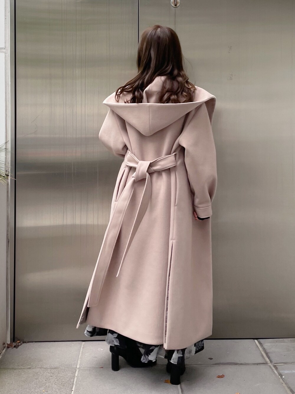 ブラック系のスカート、ブラック系のニット/セーター、ベージュ系のチェスターコートを着用したレディースの秋コーディネートの3枚目の写真