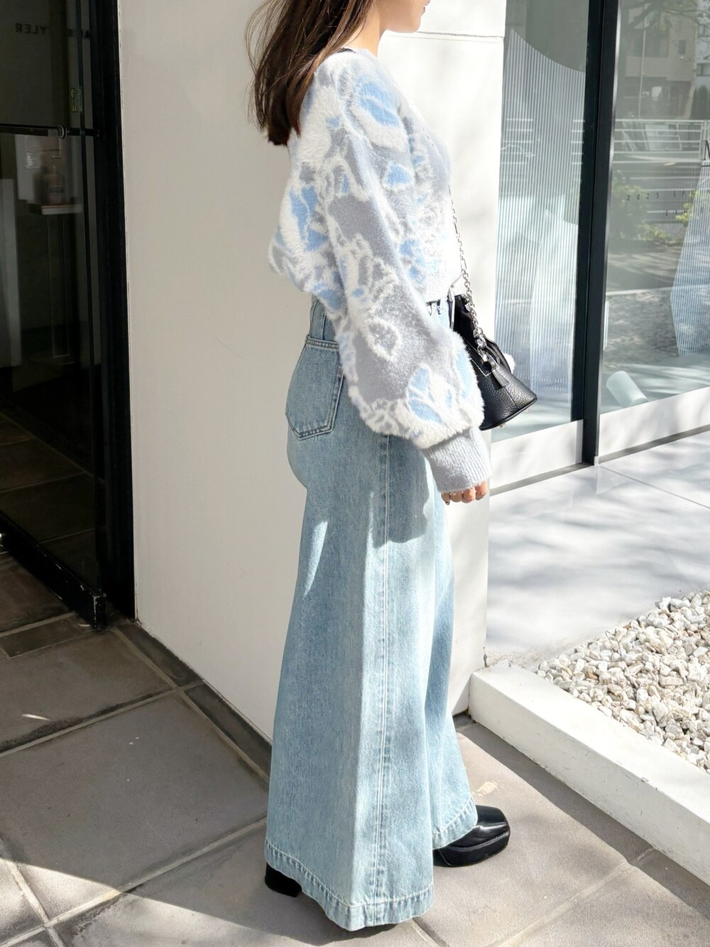 ブルー系のデニムパンツ、ブラック系のブーツ、ブルー系のニット/セーターを着用したレディースの冬コーディネートの5枚目の写真