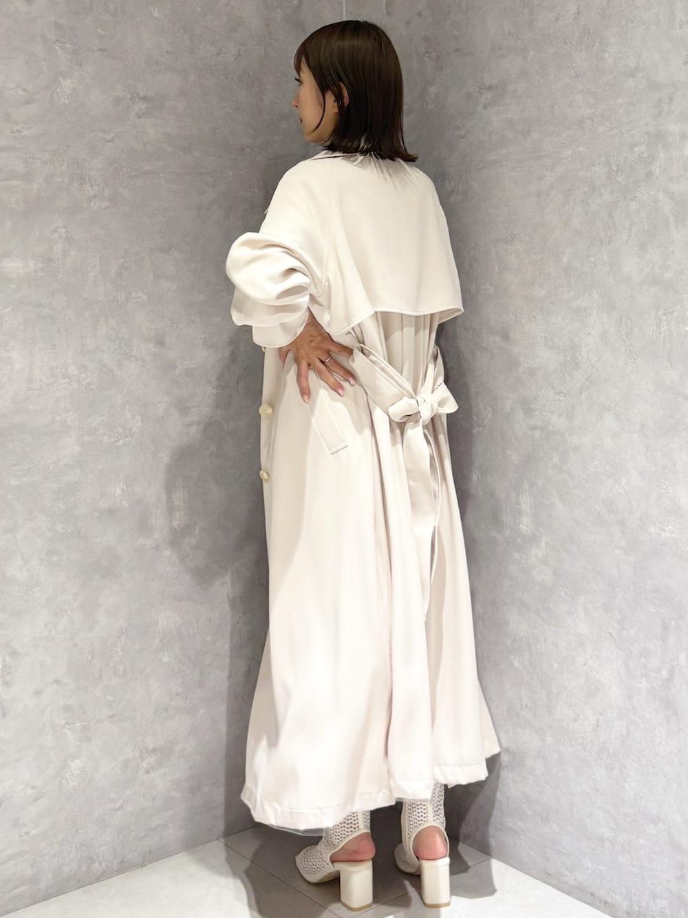 ホワイト系のワンピース、ホワイト系のブーツ、ホワイト系のトレンチコートを着用したレディースの春コーディネートの2枚目の写真