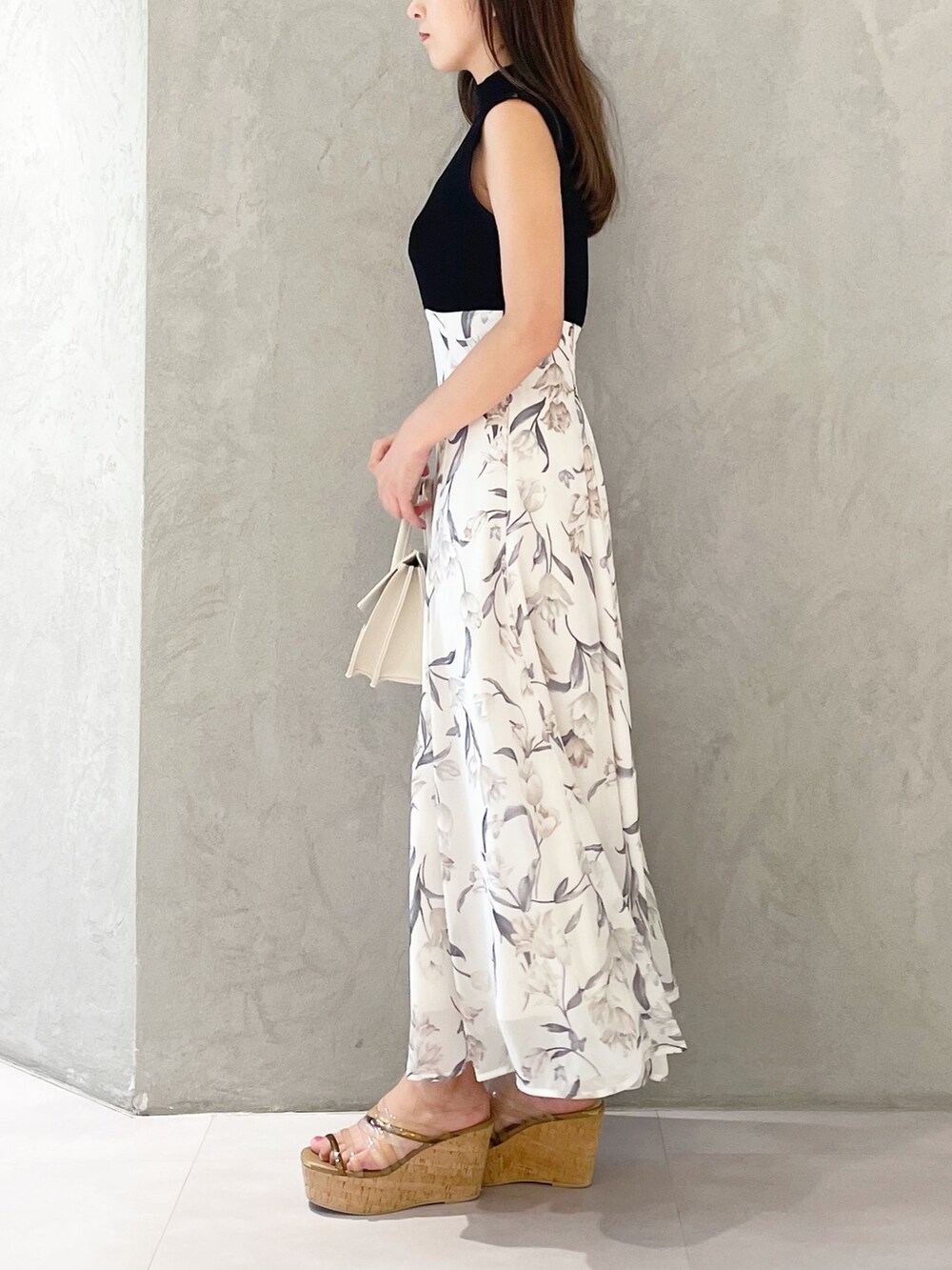 ブラック系のワンピース、ブラウン系のサンダル、ベージュ系のショルダーバッグを着用したレディースの夏コーディネートの2枚目の写真