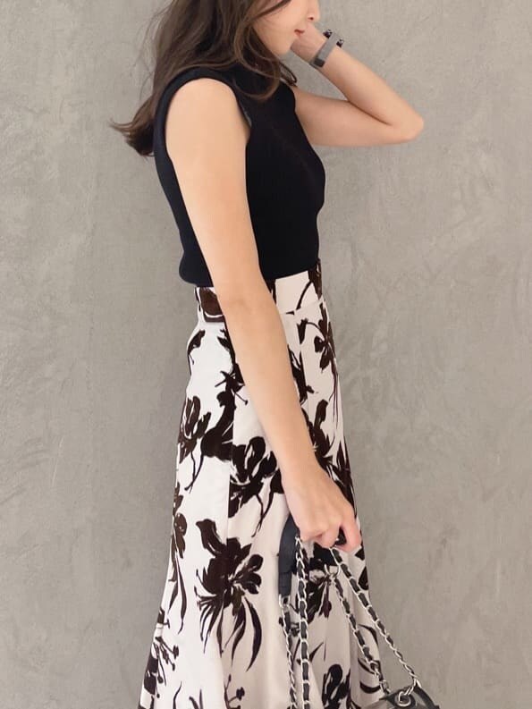 ブラック系のニット/セーター、ホワイト系のスカート、ブラック系のショルダーバッグを着用したレディースの夏コーディネートの3枚目の写真