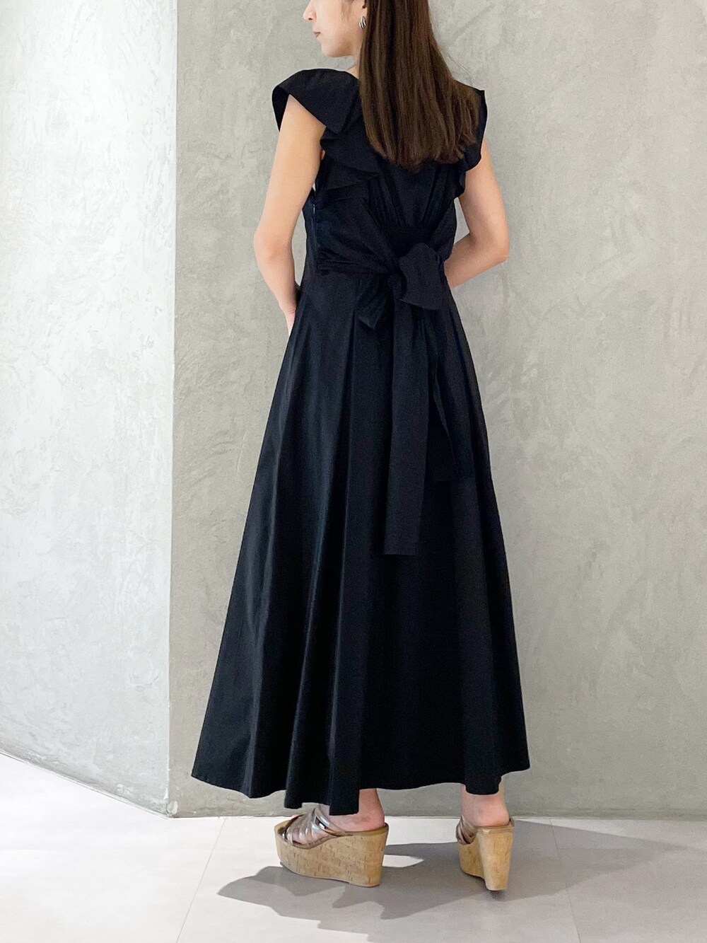 ブラック系のワンピース、ブラウン系のサンダル、ブラック系のショルダーバッグを着用したレディースの夏コーディネートの4枚目の写真