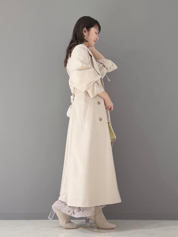 ベージュ系のその他シューズ、ベージュ系のトレンチコート、イエロー系のショルダーバッグを着用したレディースの冬コーディネートの5枚目の写真