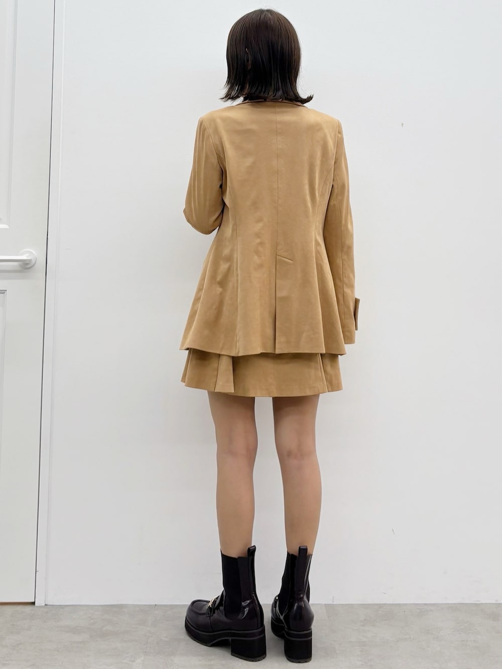 ブラウン系のニット/セーター、ブラウン系のスカート、ブラウン系のテーラードジャケットを着用したレディースの秋コーディネートの6枚目の写真