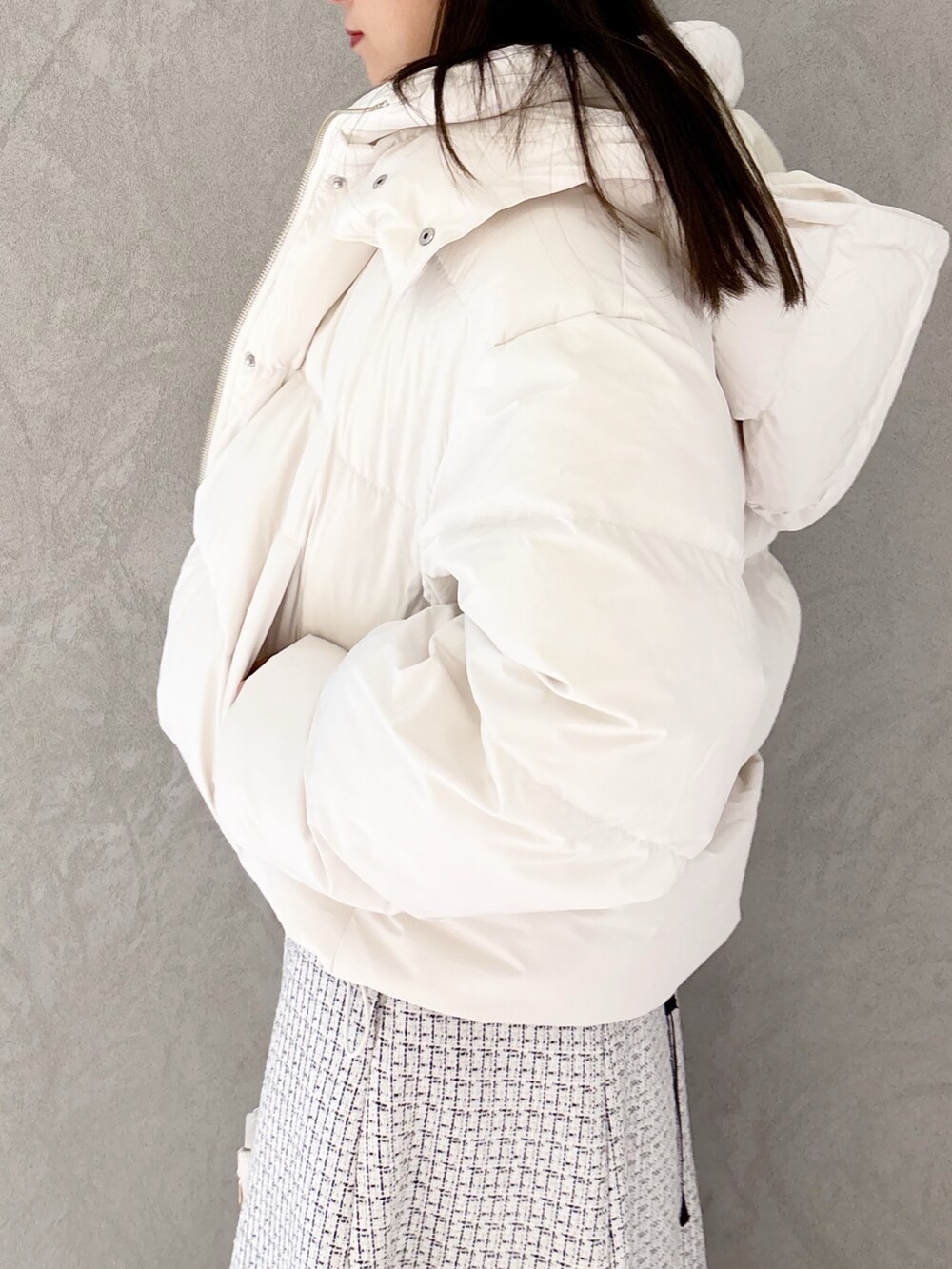 ホワイト系のスカート、ブラック系のブーツ、ホワイト系のハンドバッグを着用したレディースの冬コーディネートの3枚目の写真