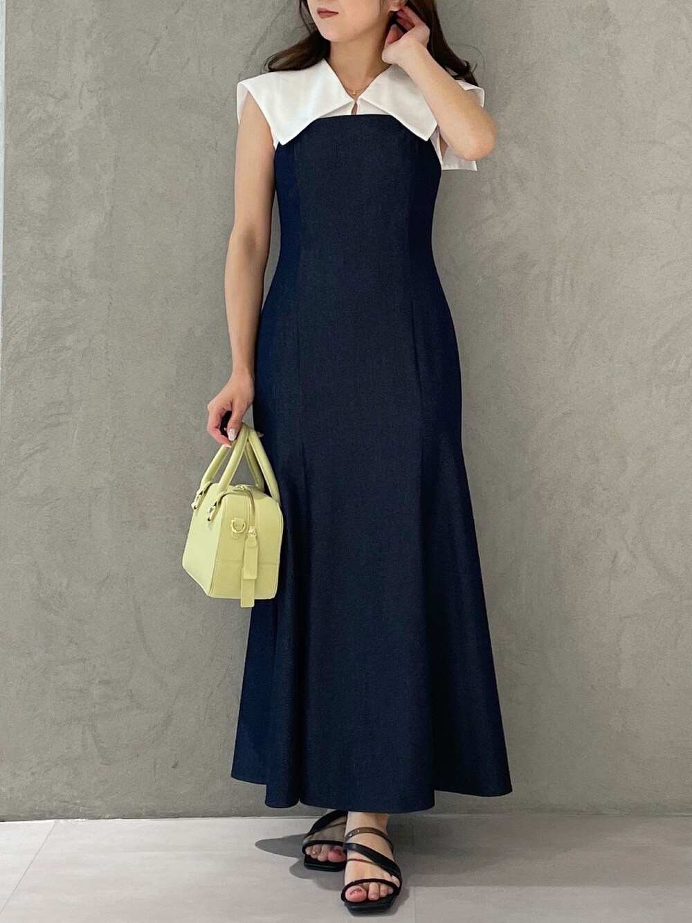 ブルー系のワンピース、イエロー系のボストンバッグ、ブラック系のサンダルを着用したレディースの春コーディネートの6枚目の写真