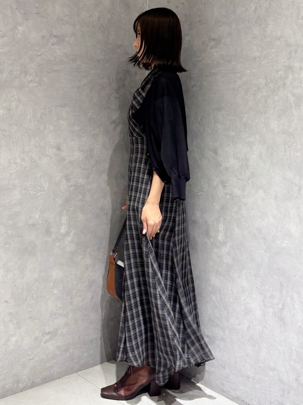 ブラック系のワンピース、ブラウン系のブーツ、ブラック系のカーディガン/ボレロを着用したレディースの夏コーディネートの2枚目の写真