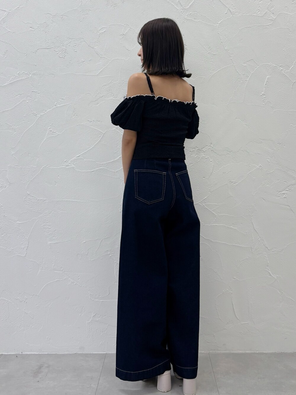 ブルー系のデニムパンツ、ホワイト系のサンダル、ブラック系のTシャツ/カットソーを着用したレディースの夏コーディネートの8枚目の写真