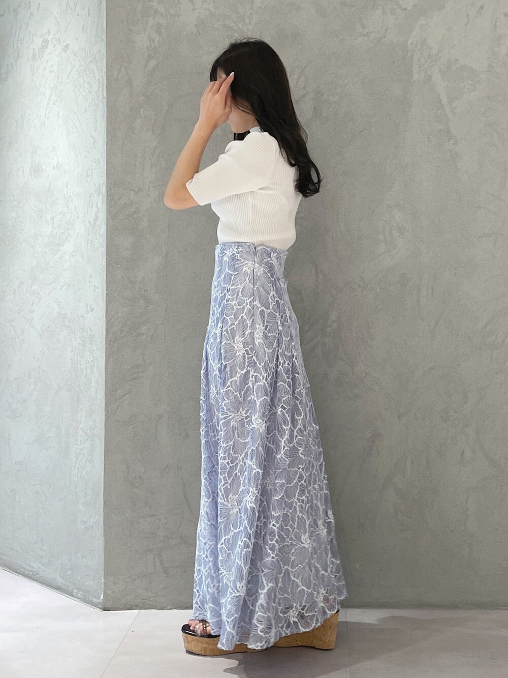 ブルー系のスカート、ブラック系のサンダル、ホワイト系のニット/セーターを着用したレディースの春コーディネートの3枚目の写真