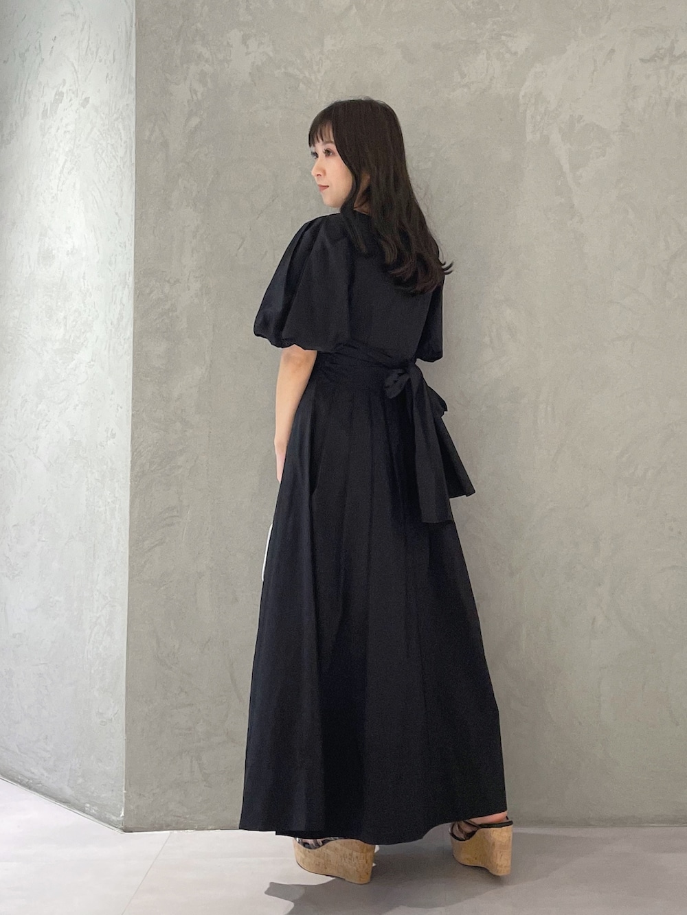 ブラック系のサンダル、ブルー系のハンドバッグ、ブラック系のワンピースを着用したレディースの春コーディネートの5枚目の写真