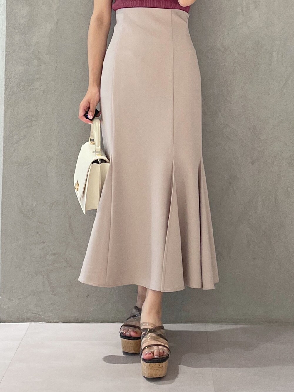 ブラック系のサンダル、ホワイト系のハンドバッグ、ピンク系のスカートを着用したレディースの春コーディネートの6枚目の写真