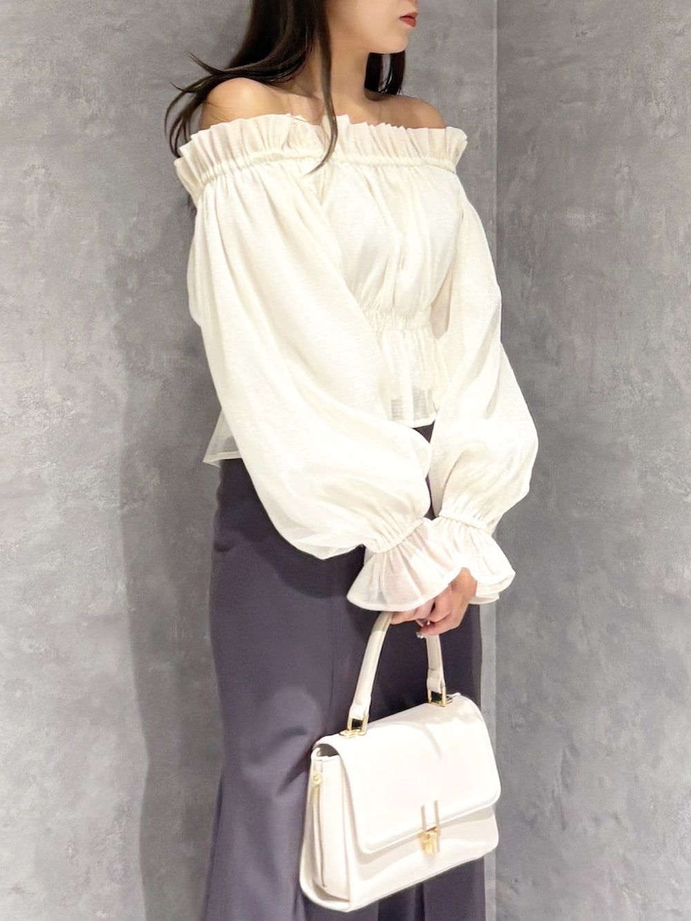 ホワイト系のハンドバッグ、ホワイト系のパンプス、ホワイト系のシャツ/ブラウスを着用したレディースの春コーディネートの5枚目の写真