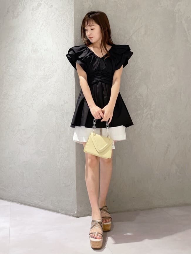 イエロー系のショルダーバッグ、グリーン系のサンダル、ブラック系のシャツ/ブラウスを着用したレディースの春コーディネートの7枚目の写真
