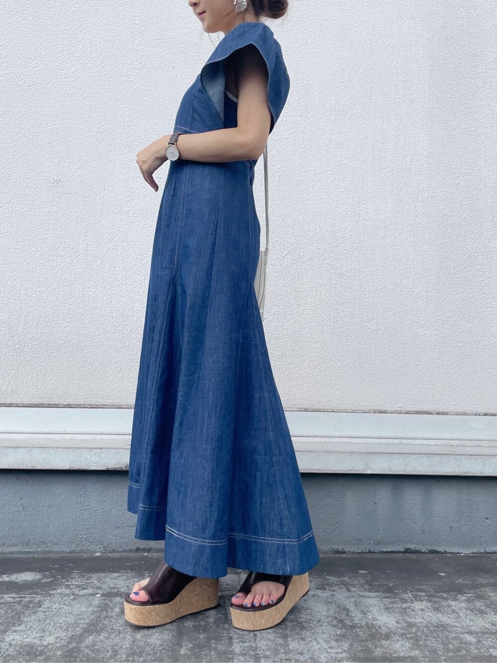 ブルー系のワンピース、ブラウン系のサンダル、ホワイト系のハンドバッグを着用したレディースの夏コーディネートの5枚目の写真