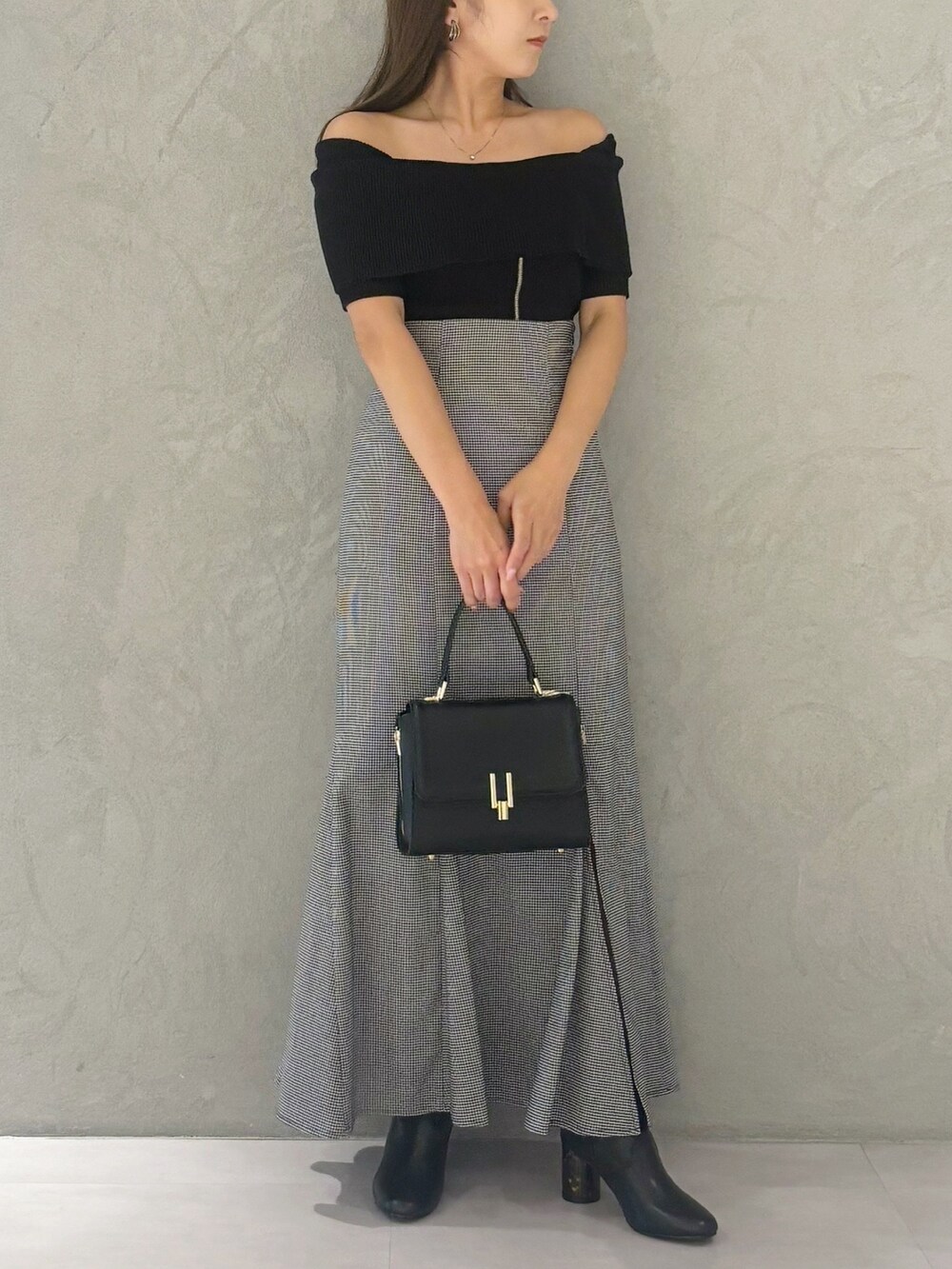 その他のスカート、ブラック系のブーツ、ブラック系のショルダーバッグを着用したレディースの秋コーディネートの2枚目の写真