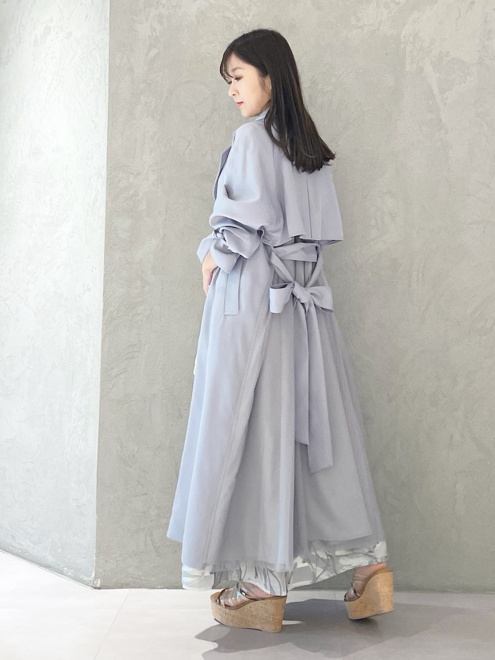 ブルー系のトレンチコート、ブラウン系のサンダル、ホワイト系のショルダーバッグを着用したレディースの春コーディネートの4枚目の写真