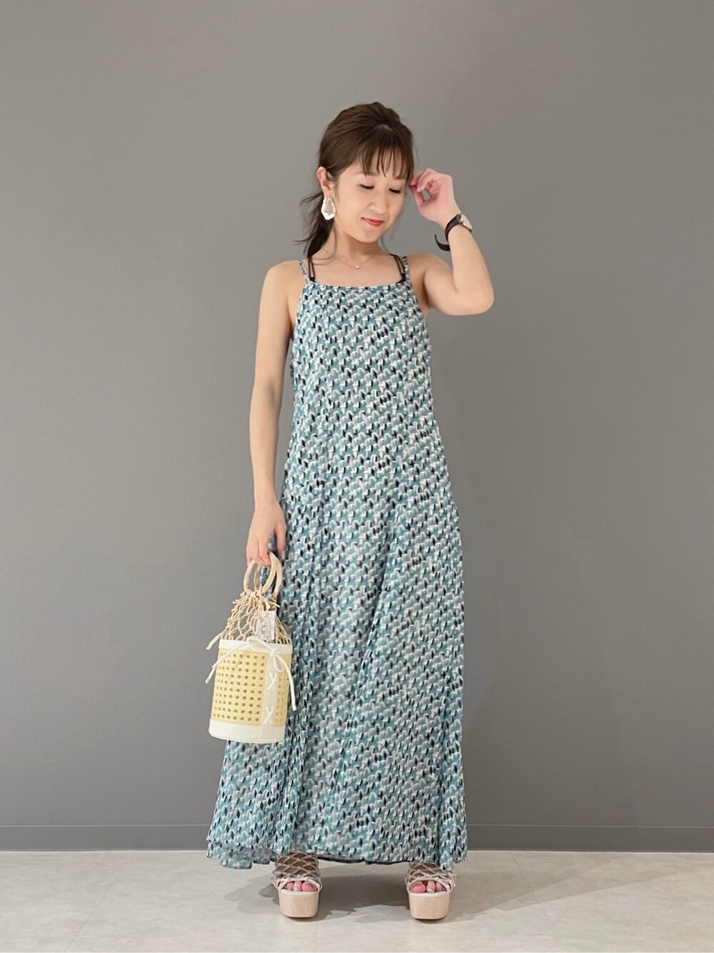 グリーン系のワンピース、ホワイト系のハンドバッグ、ホワイト系のサンダルを着用したレディースの春コーディネートの5枚目の写真