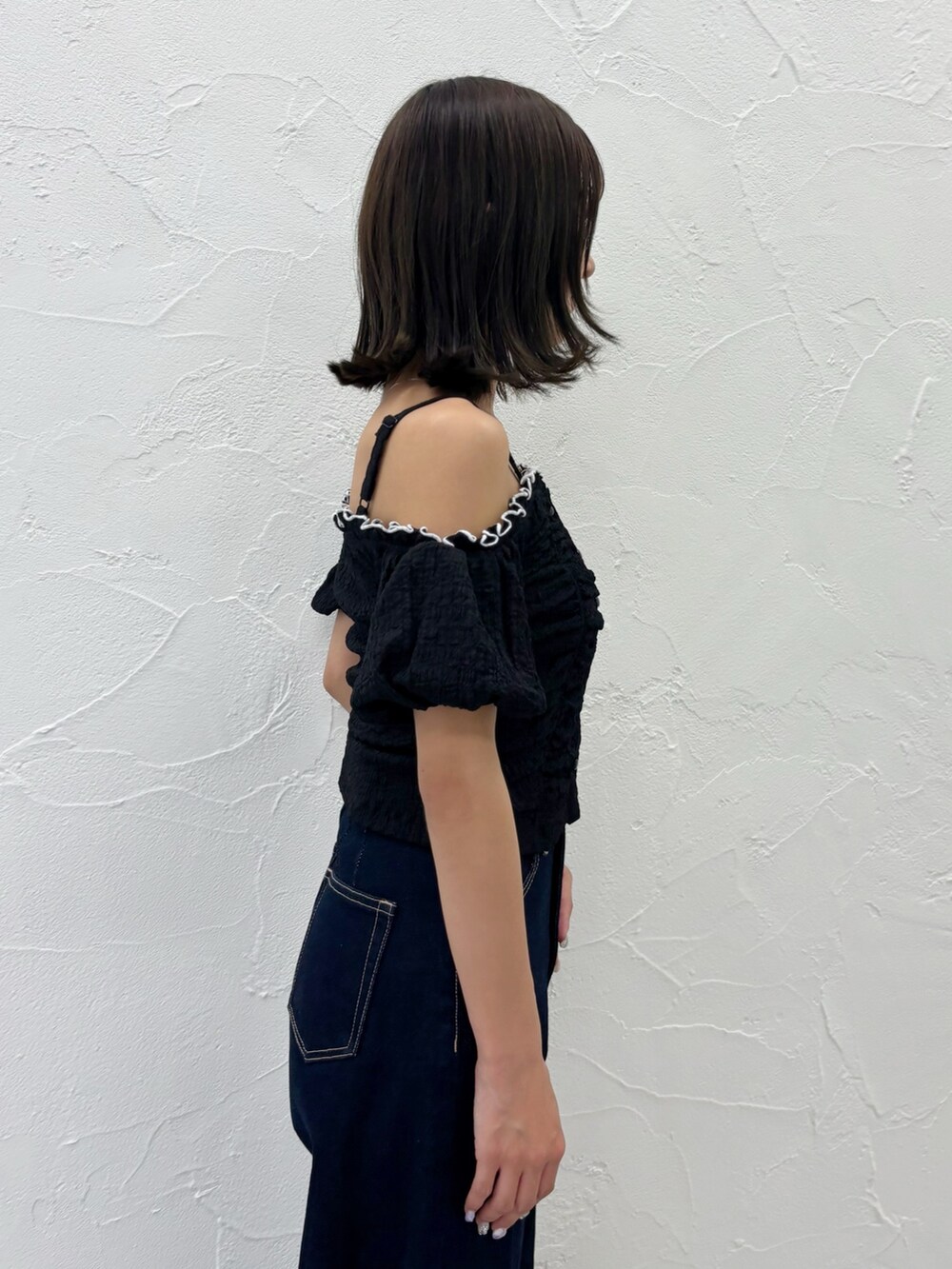 ブルー系のデニムパンツ、ホワイト系のサンダル、ブラック系のTシャツ/カットソーを着用したレディースの夏コーディネートの2枚目の写真