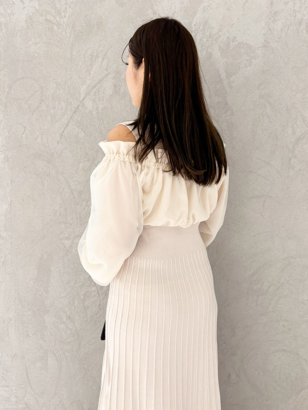 ホワイト系のワンピース、ブラウン系のブーツ、ブラウン系のハンドバッグを着用したレディースの冬コーディネートの2枚目の写真