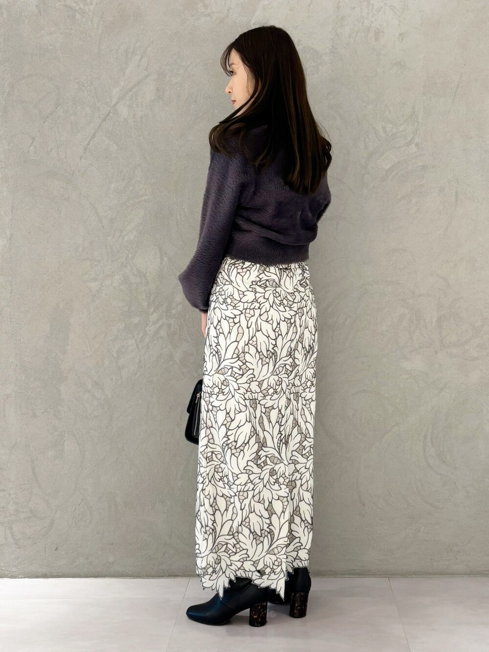 ホワイト系のスカート、ブラック系のブーツ、ブラック系のショルダーバッグを着用したレディースの冬コーディネートの7枚目の写真