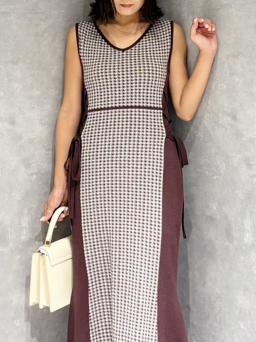 ブラウン系のワンピース、ブラウン系のブーツ、ホワイト系のハンドバッグを着用したレディースの夏コーディネートの6枚目の写真