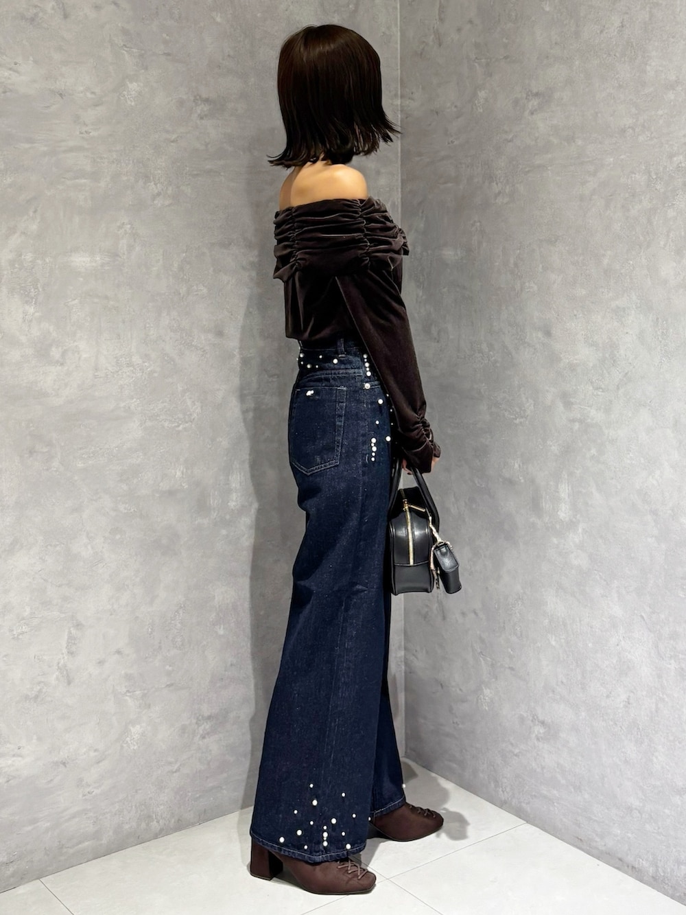 ブルー系のデニムパンツ、ブラウン系のTシャツ/カットソー、ブラウン系のブーツを着用したレディースの秋コーディネートの3枚目の写真