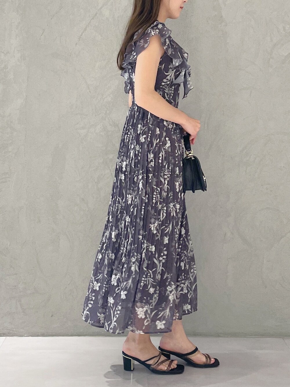 ブラック系のハンドバッグ、ブラック系のサンダル、グレー系のワンピースを着用したレディースの春コーディネートの4枚目の写真