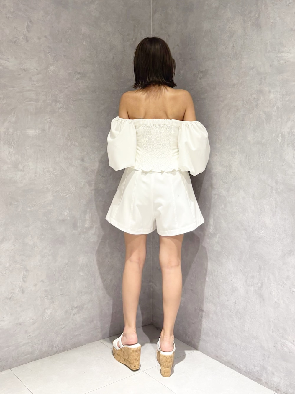 ホワイト系のその他パンツ、ホワイト系のサンダル、ブラウン系のハンドバッグを着用したレディースの夏コーディネートの3枚目の写真
