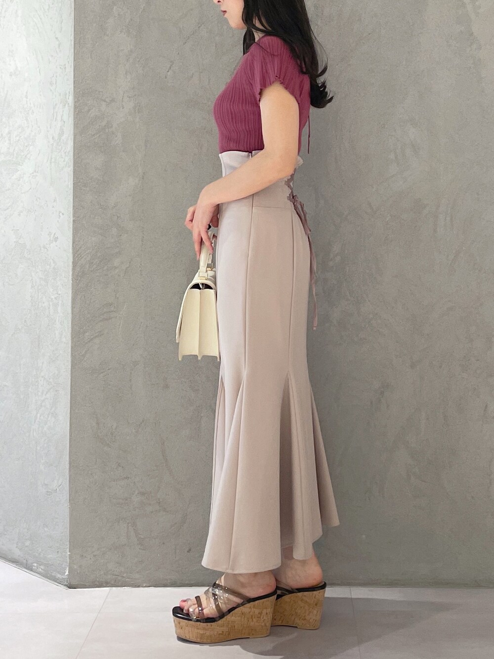 ブラック系のサンダル、ホワイト系のハンドバッグ、ピンク系のスカートを着用したレディースの春コーディネートの4枚目の写真