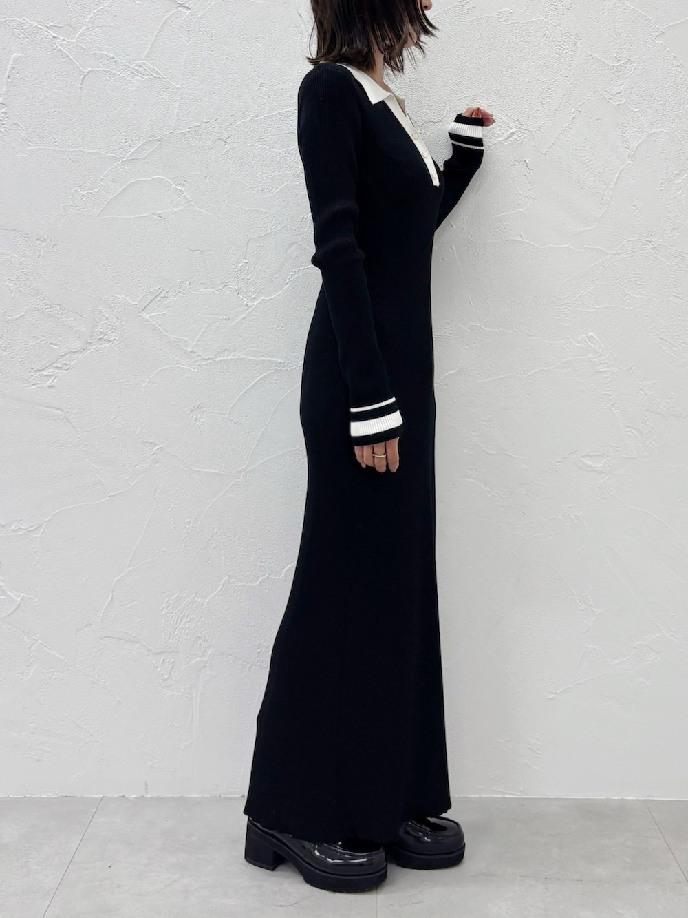 ブラック系のワンピース、ブラック系のブーツを着用したレディースの秋コーディネートの6枚目の写真