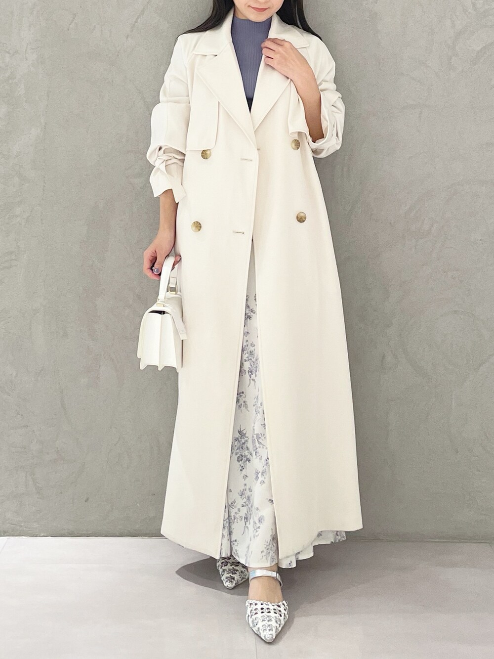 シルバー系のパンプス、ホワイト系のショルダーバッグ、ブルー系のニット/セーターを着用したレディースの春コーディネートの6枚目の写真