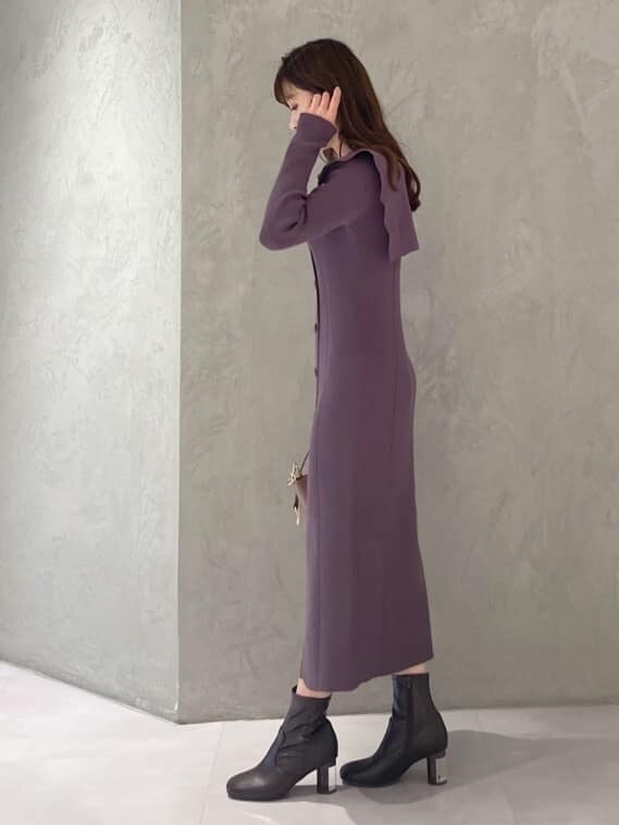 パープル系のワンピース、ブラウン系のブーツ、ブラウン系のハンドバッグを着用したレディースの秋コーディネートの4枚目の写真