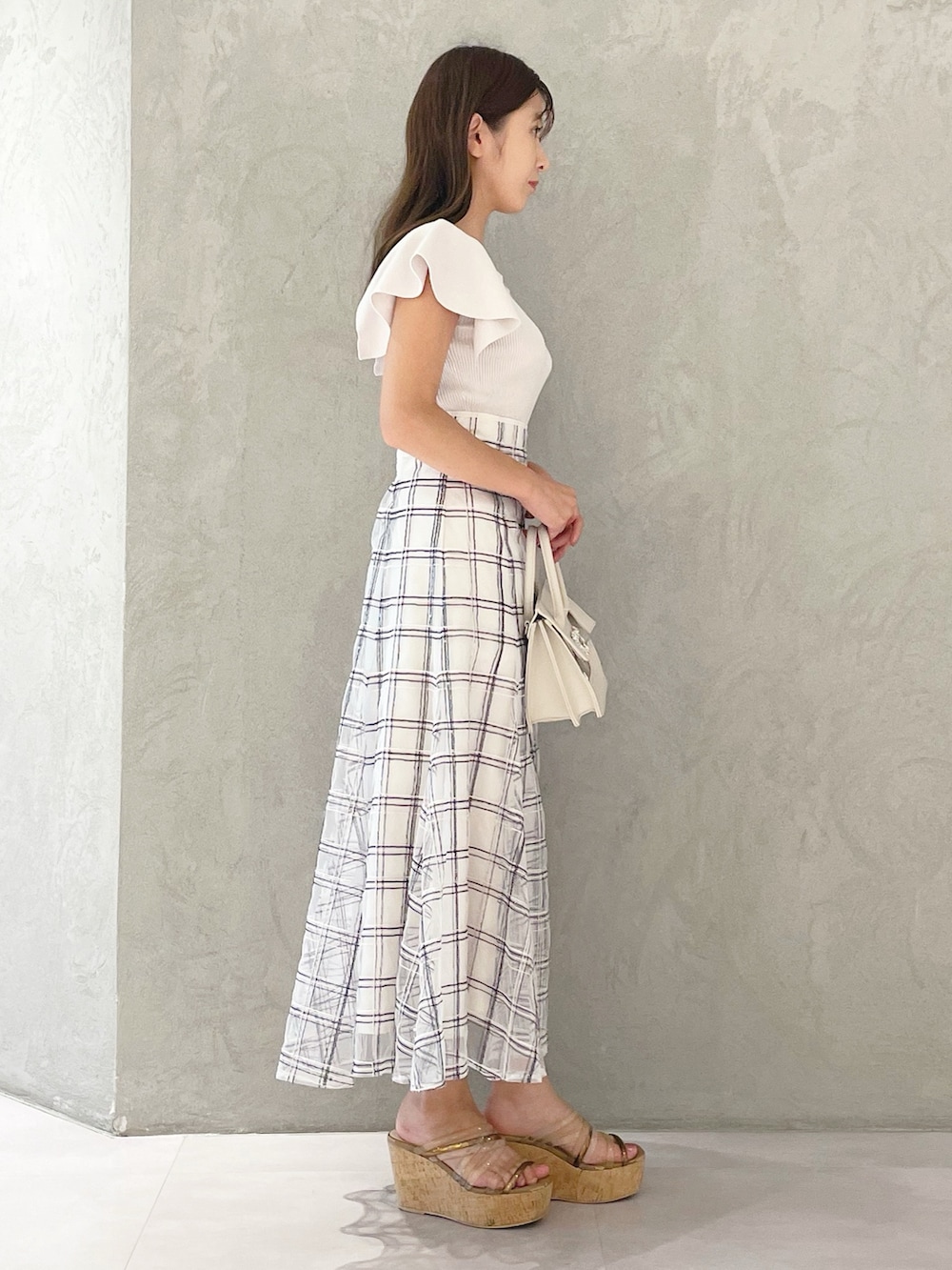 ホワイト系のスカート、ブラウン系のサンダル、ベージュ系のショルダーバッグを着用したレディースの夏コーディネートの4枚目の写真