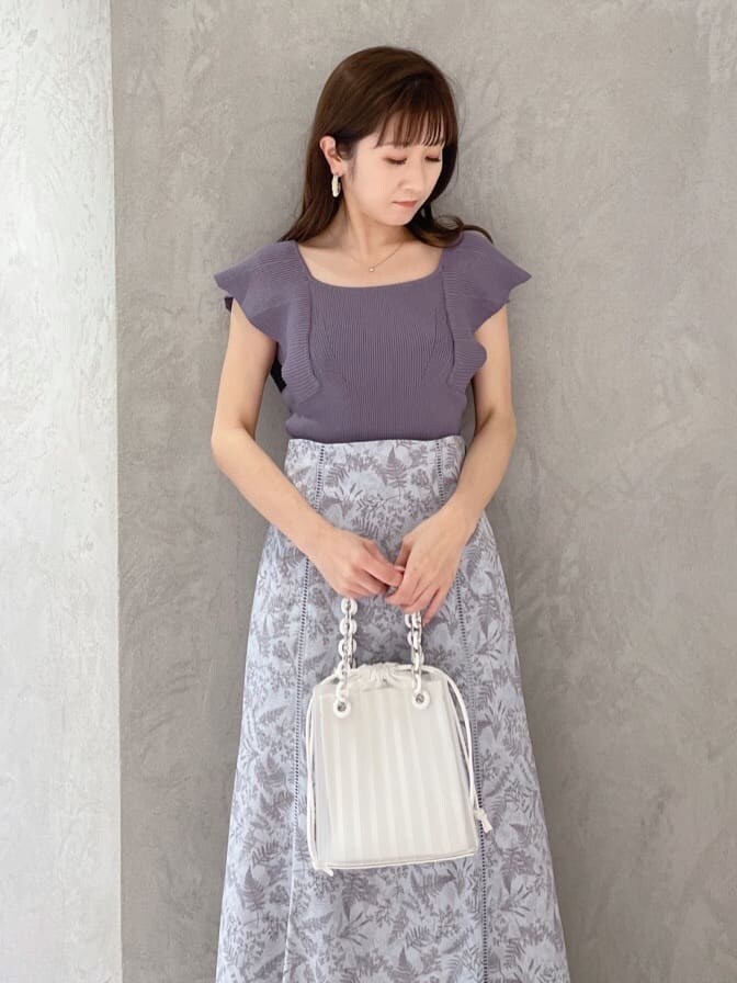 ホワイト系のハンドバッグ、グリーン系のサンダル、ブルー系のニット/セーターを着用したレディースの春コーディネートの7枚目の写真