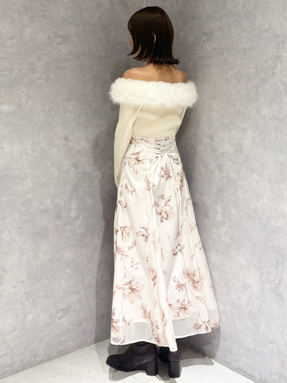 ホワイト系のワンピース、ブラウン系のブーツ、ブラック系のハンドバッグを着用したレディースの冬コーディネートの2枚目の写真