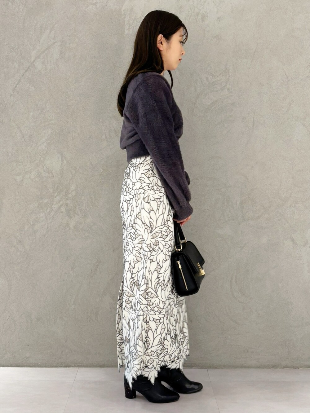 ホワイト系のスカート、ブラック系のブーツ、ブラック系のショルダーバッグを着用したレディースの冬コーディネートの5枚目の写真