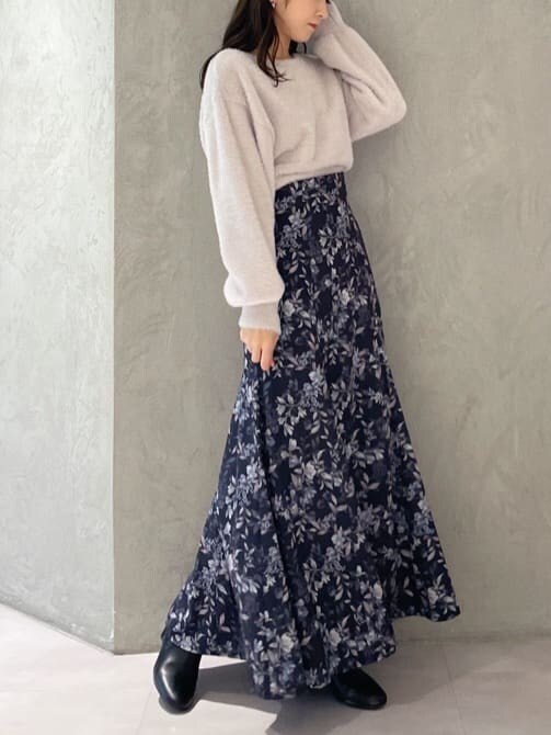 ピンク系のニット/セーター、ブルー系のスカートを着用したレディースの秋コーディネートの4枚目の写真