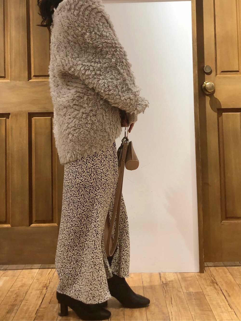 ホワイト系のスカート、ホワイト系のニット/セーター、グレー系のカーディガン/ボレロを着用したレディースの冬コーディネートの5枚目の写真